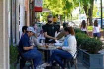 Patrons are assisted while dining along a sidewalk on Franklin Street in Chapel Hill, N.C., Fri ...