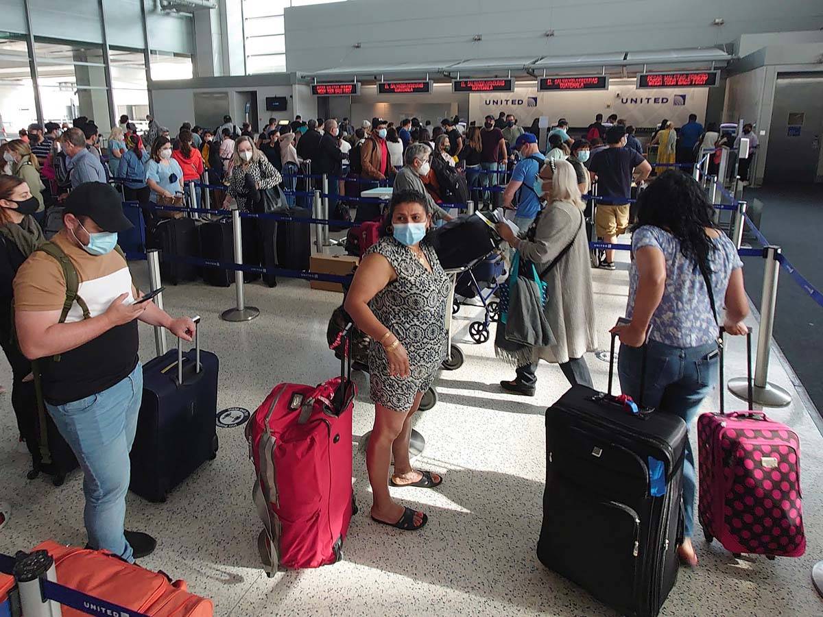In this Sunday, May 16, 2021, file photo, airline passengers wait to check-in at George Bush In ...