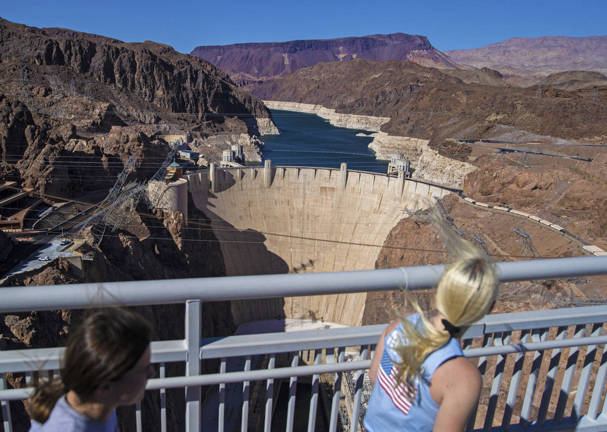 Tourists look out at Lake Mead and the Hoover Dam while walking on the Mike O'CallaghanÐPa ...