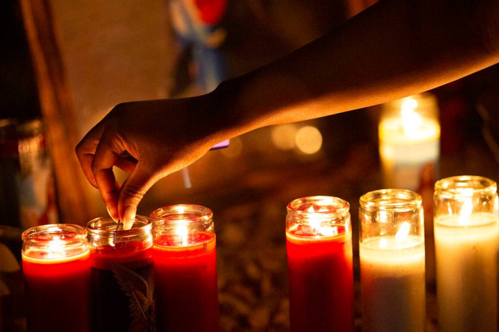 Attendees keep the candles lit at a vigil for Walter Anderson near the intersection where he wa ...