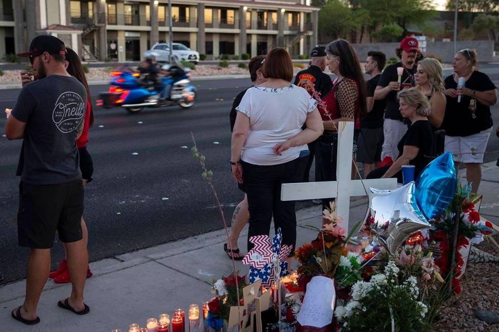 A motorcycle passes a vigil for Walter Anderson near the intersection where he was killed, Sout ...