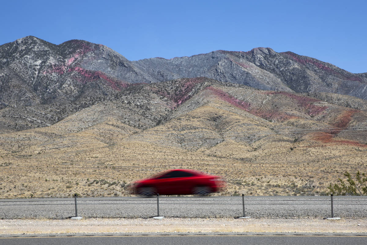 Fire retardant is present on the western slope of Potosi Mountain while crews battle the Sandy ...