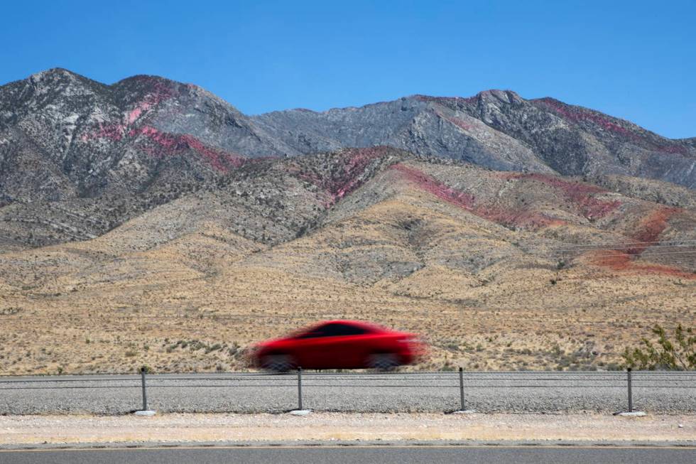 Fire retardant is present on the western slope of Potosi Mountain while crews battle the Sandy ...