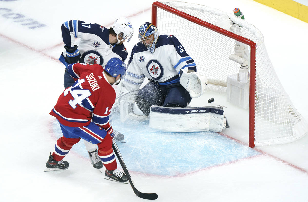 Montreal Canadiens' Nick Suzuki scores a power play goal past Winnipeg Jets goaltender Connor H ...