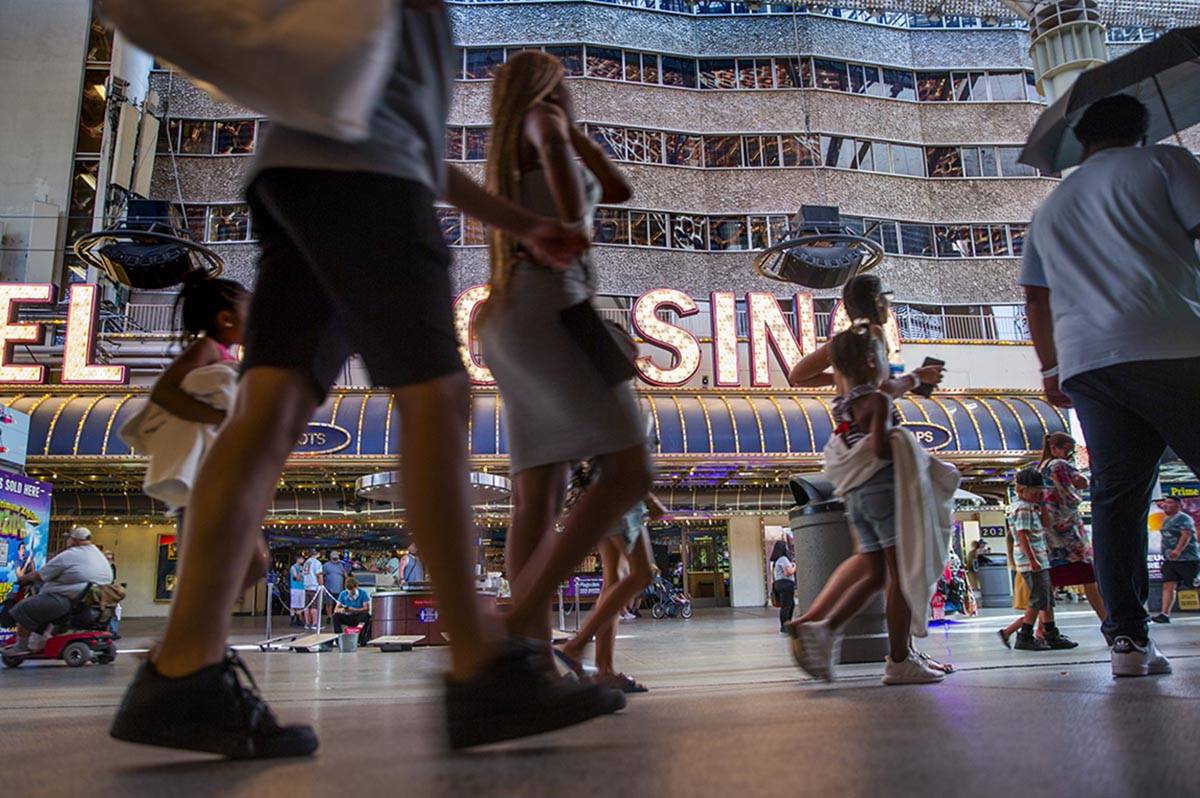 Visitors wander along the shops and casinos at the Fremont Street Experience on Monday, June 14 ...