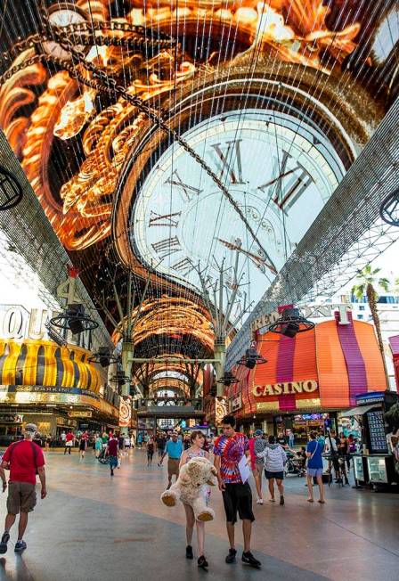 Visitors wander along the shops and casinos as the Viva Vision plays above at the Fremont Stree ...