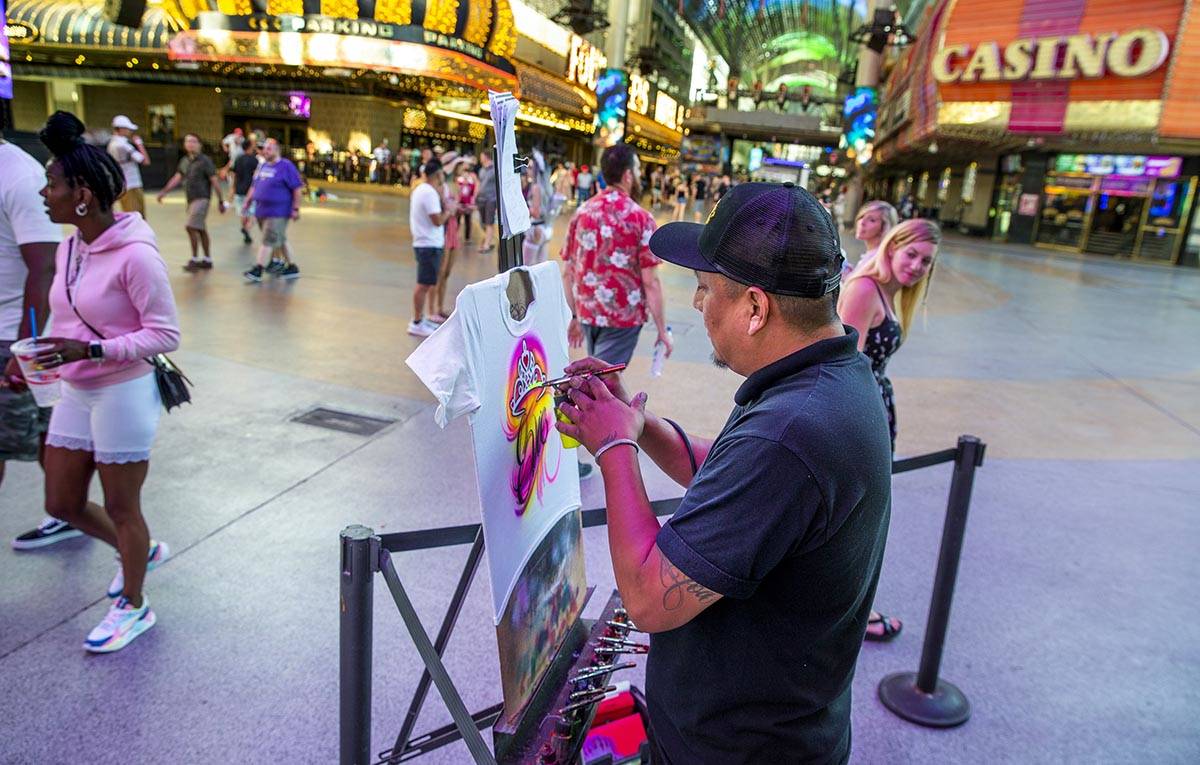 Artist Nate Tsosie with Airbrush Las Vegas creates another custom t-shirt at the Fremont Street ...