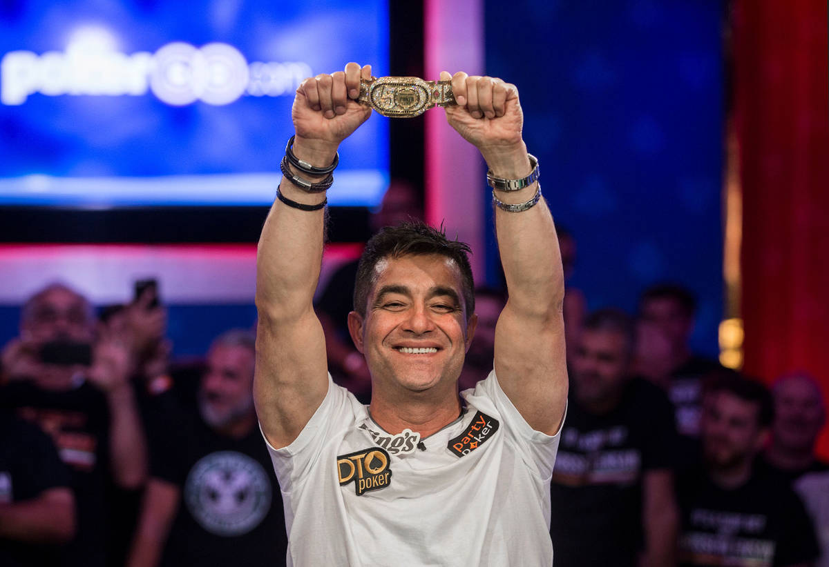 Hossein Ensan, from Germany, lifts the championship bracelet after winning the World Series of ...