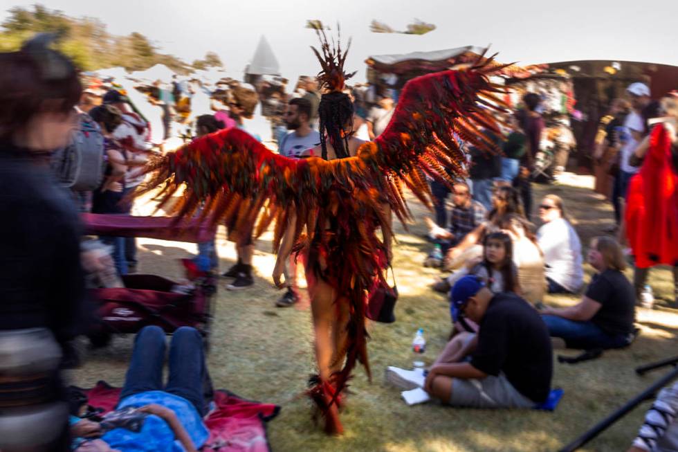 An attendee in bird costume makes her way through the crowd during the Age of Chivalry Renaissa ...