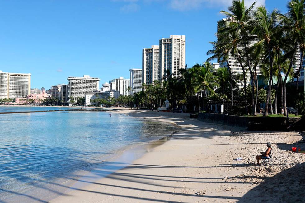 In this Oct. 2, 2020, file photo, a man sits on Waikiki Beach in Honolulu. (AP Photo/Caleb Jone ...