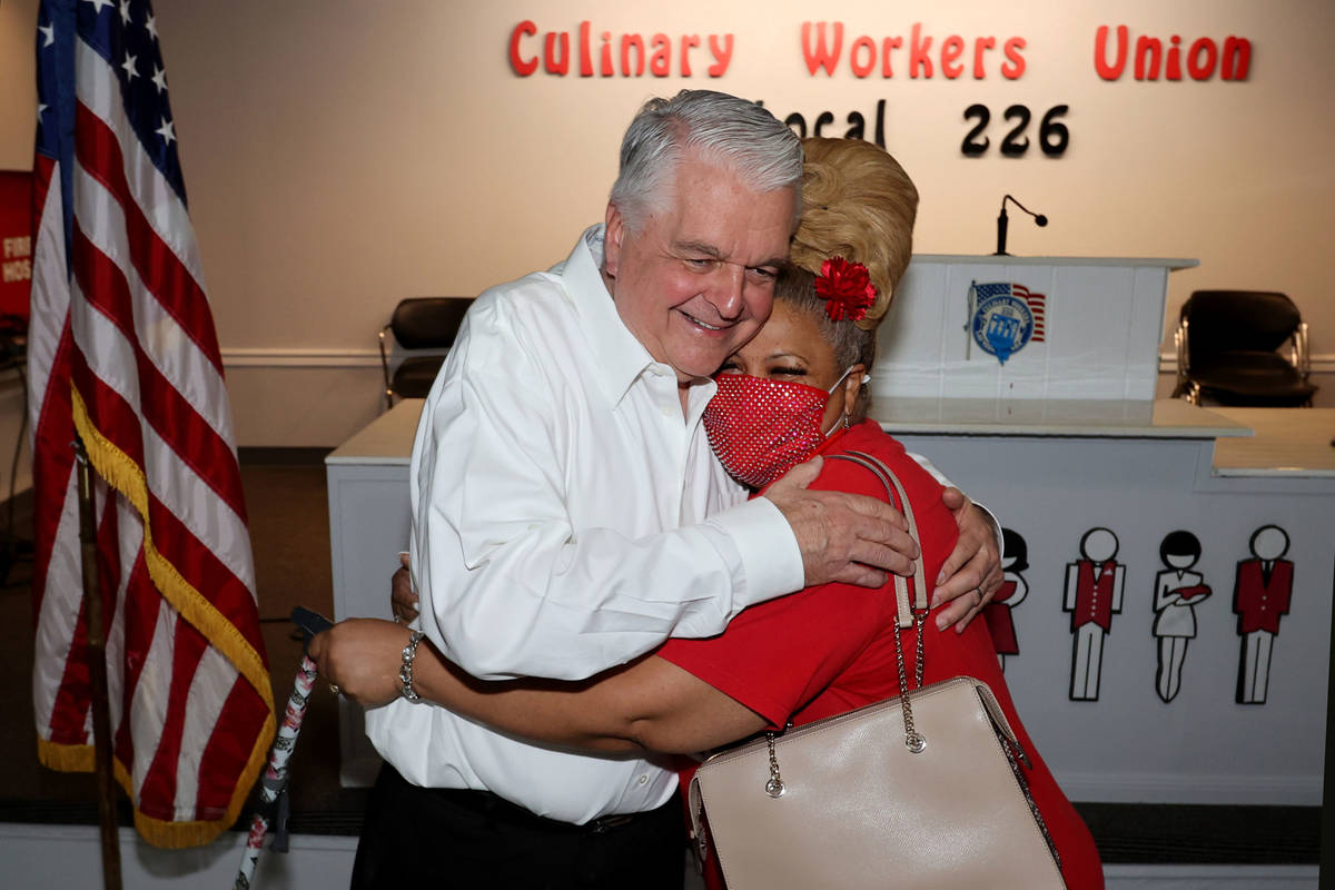 Culinary Workers Union Local 226 member Yolanda Scott, right, greets Gov. Steve Sisolak at her ...
