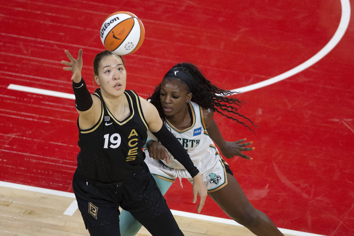Las Vegas Aces center JiSu Park (19) reaches for control of the ball while New York Liberty for ...