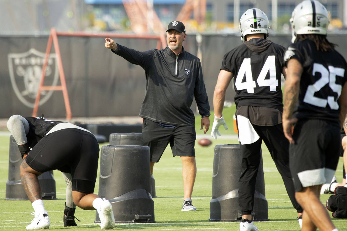 Raiders defensive coordinator Gus Bradley instructs defensive end Kendal Vickers (93) and lineb ...