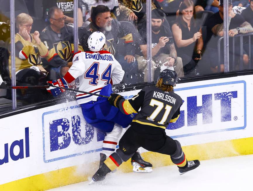 Golden Knights' William Karlsson (71) takes Montreal Canadiens' Joel Edmundson (44) to the glas ...