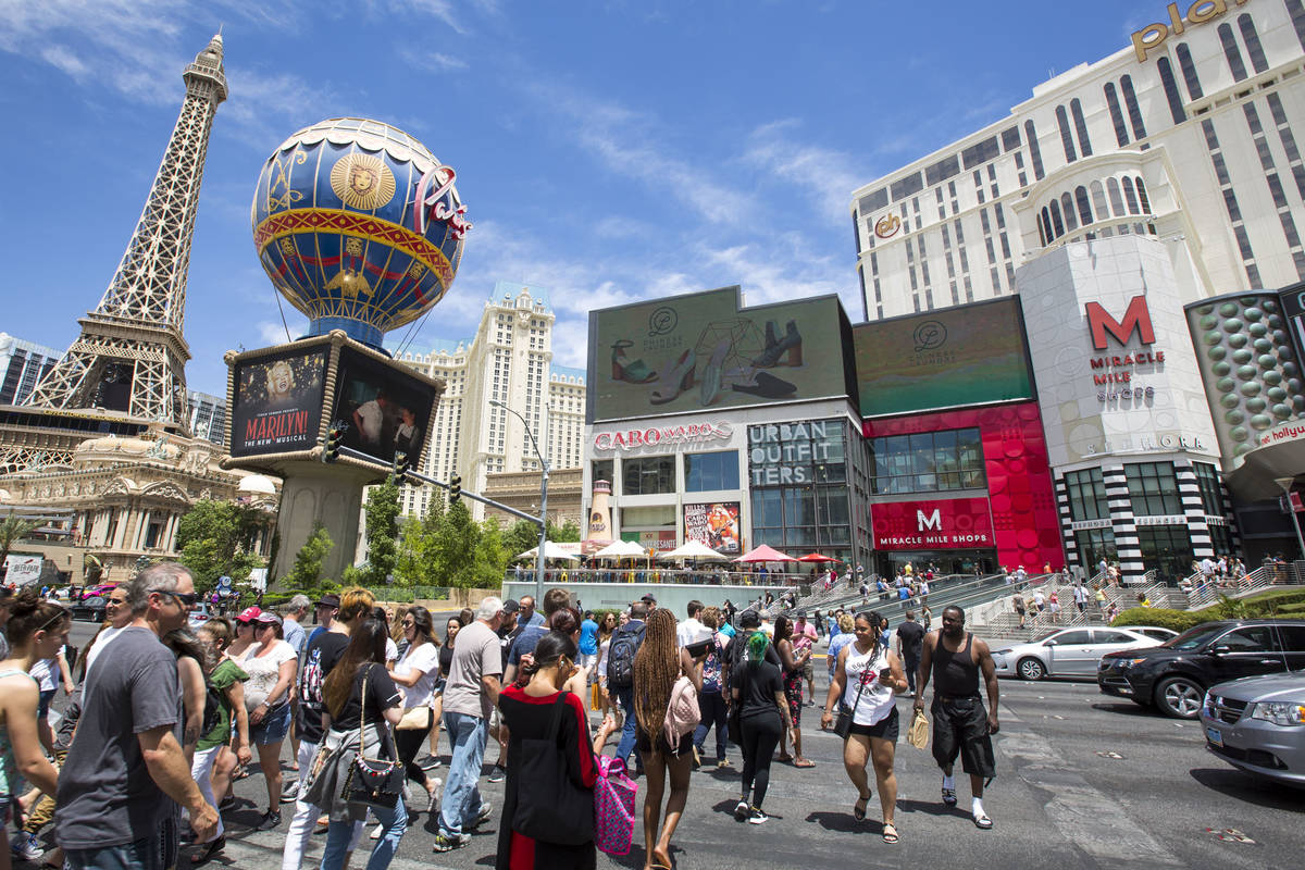 People cross the street outside the Paris Las Vegas and Planet Hollywood Resort on The Strip in ...