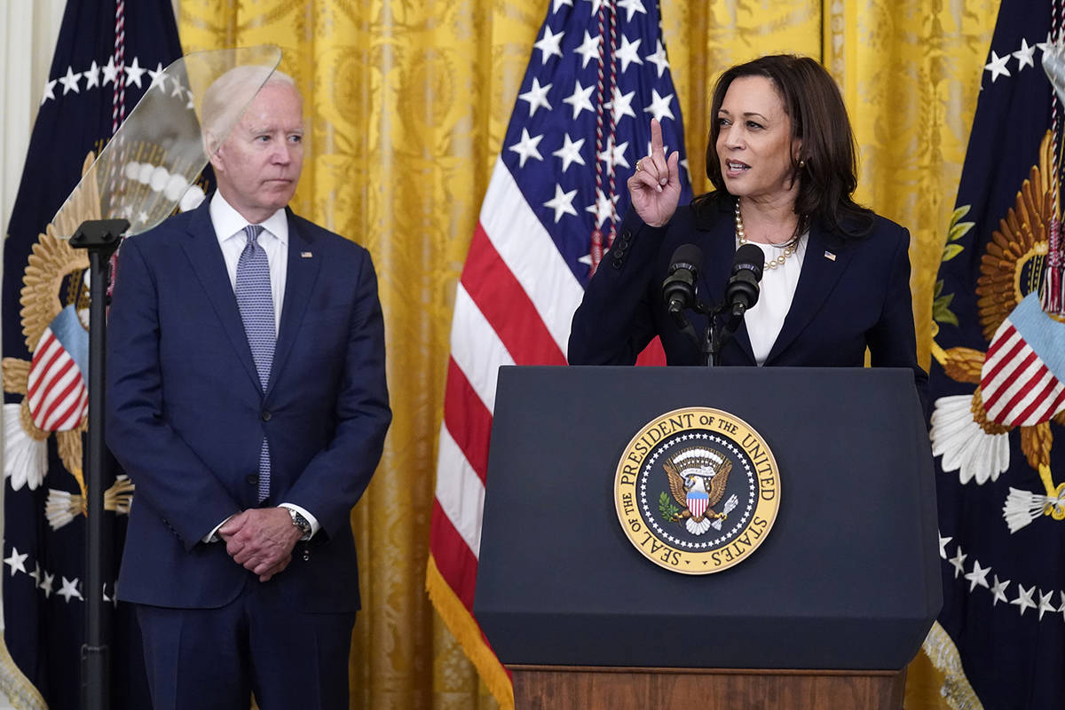 President Joe Biden listens as Vice President Kamala Harris speaks during an event to mark the ...