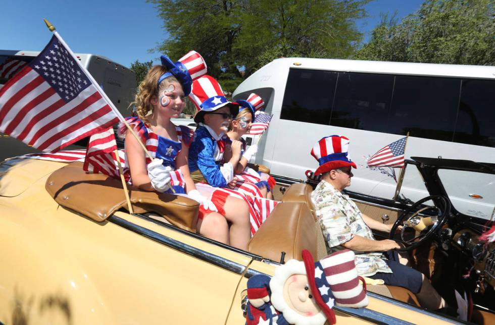 Parade goers wave to spectators in the crowd during the 25th annual Summerlin Council Patriotic ...