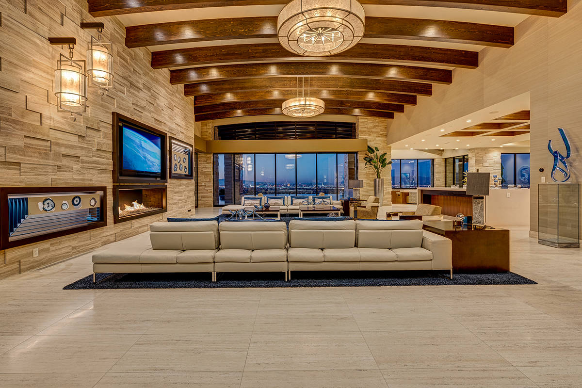 The living room features wooden beams, modern fireplace and access to the nearly 6,000-square-f ...
