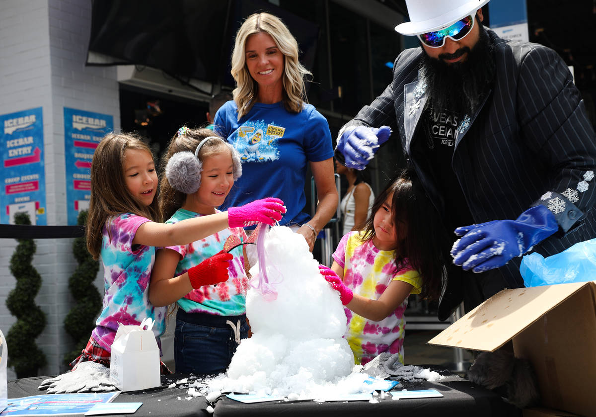 Marco Villarreal, known as "Vegas Ice Man," helps his daughters Mabel Villarreal, 7, and Mavis ...