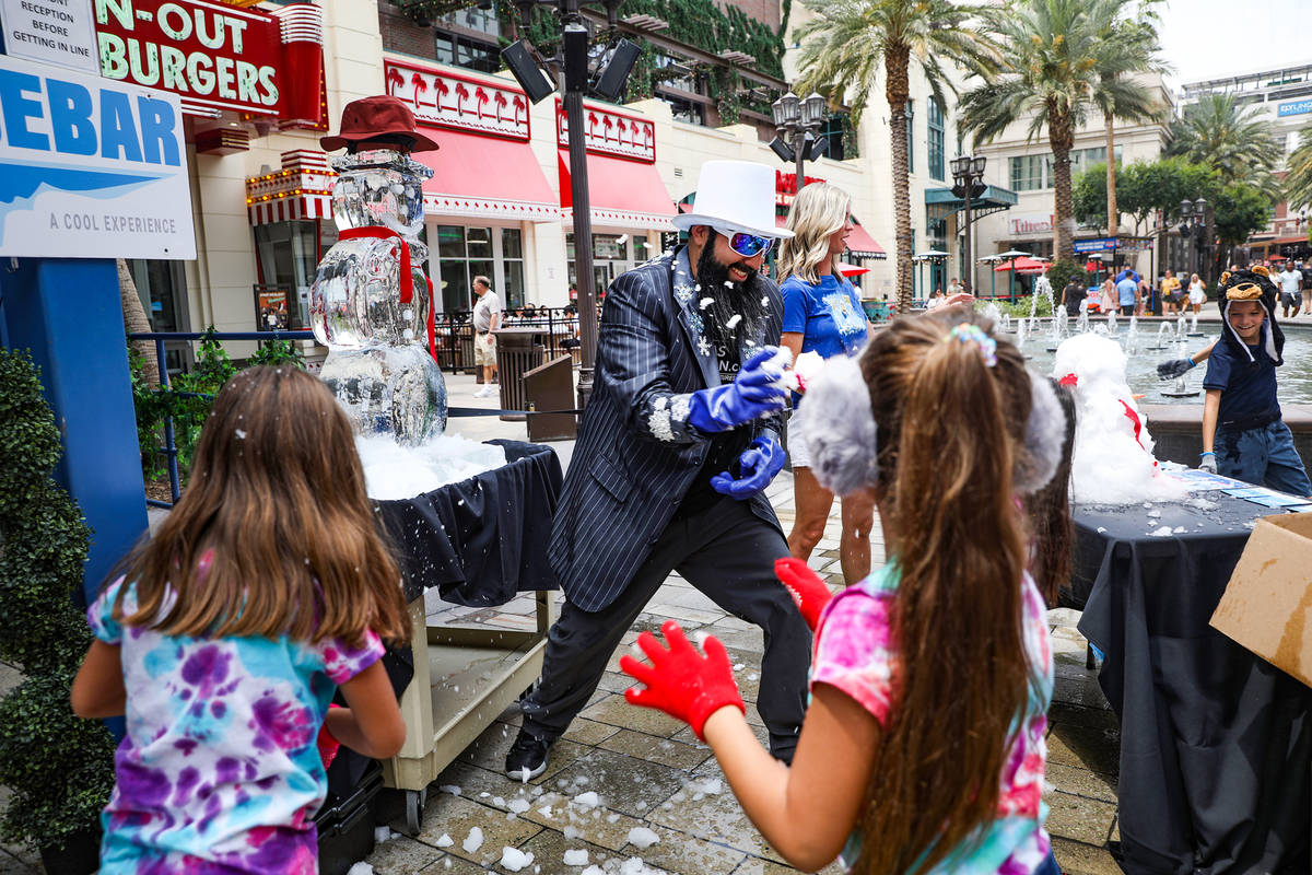 Marco Villarreal, known as "Vegas Ice Man," has a snowball fight with his daughters at an event ...