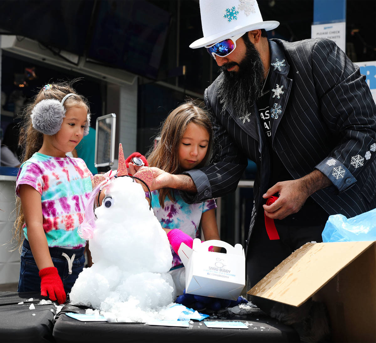 Marco Villarreal, known as "Vegas Ice Man," helps his daughters Millie Villarreal, 5, from left ...