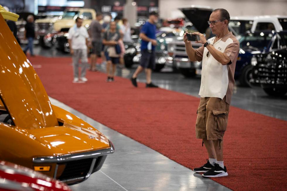 Erwin of Las Vegas, who declined to give a last name, takes photos in the showroom floor while ...