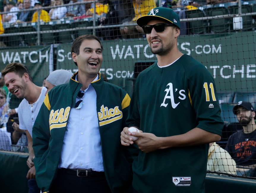 Oakland Athletics president Dave Kaval, left, laughs with Golden State Warriors basketball play ...