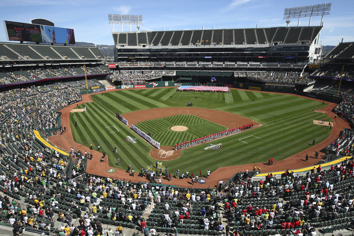 FILE - The Los Angeles Angels and Oakland Athletics stand for the national anthem at the Oaklan ...