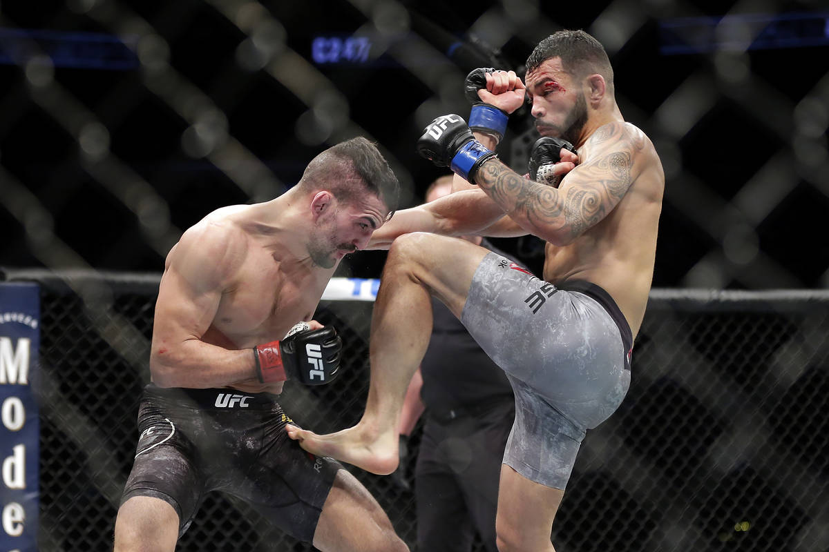 Mirsad Bektic, left, punches as Dan Ige, right, throws a knee during a featherweight mixed mart ...