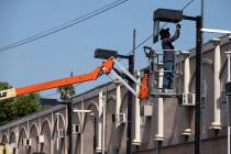 A worker fixes a street lamp in the Van Nuys section of Los Angeles on Thursday, June 17, 2021. ...