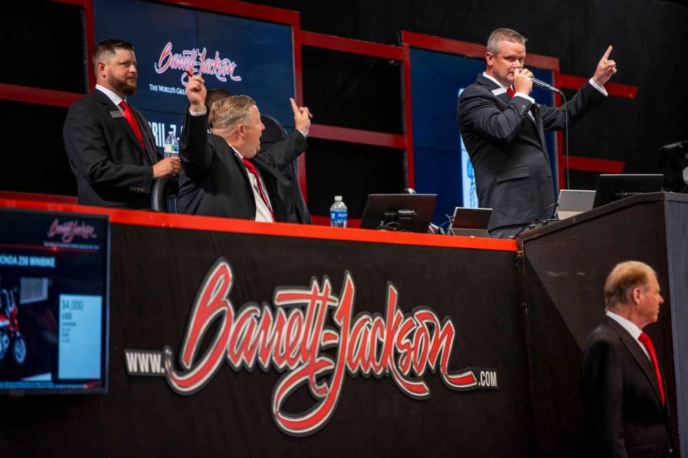 Auctioneer Seth Andrews, right, calls out the final bid on the front podium during the Barrett- ...
