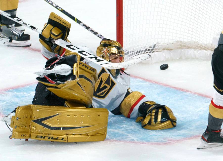 Vegas Golden Knights goaltender Marc-Andre Fleury lies on the ice with the puck in the net on a ...