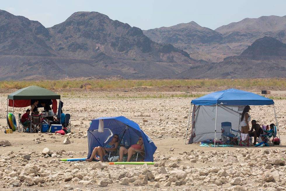 Beach-goers shade themselves along Boulder Beach at Lake Mead on Saturday, June 19, 2021, near ...