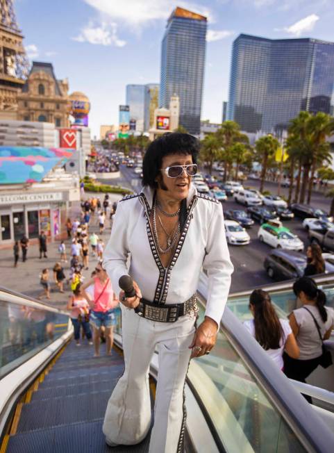 Chris Johnson, known as "Counterfeit Elvis," makes his way up the escalator on the Strip during ...