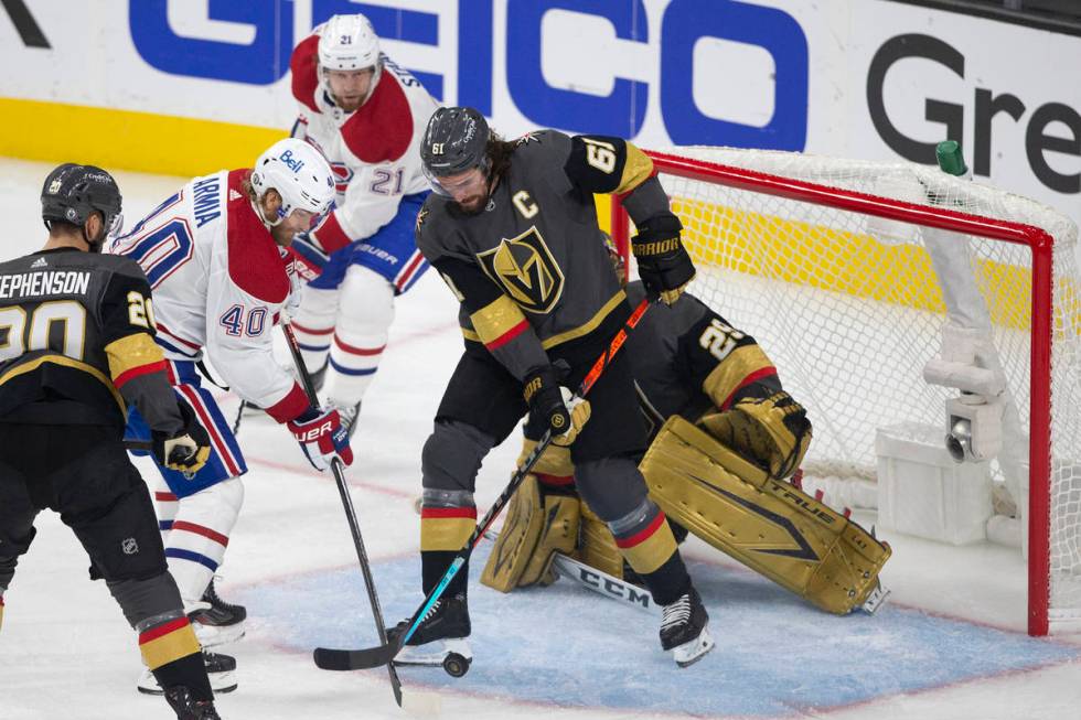 Golden Knights right wing Mark Stone (61) defends goaltender Marc-Andre Fleury (29) while Canad ...