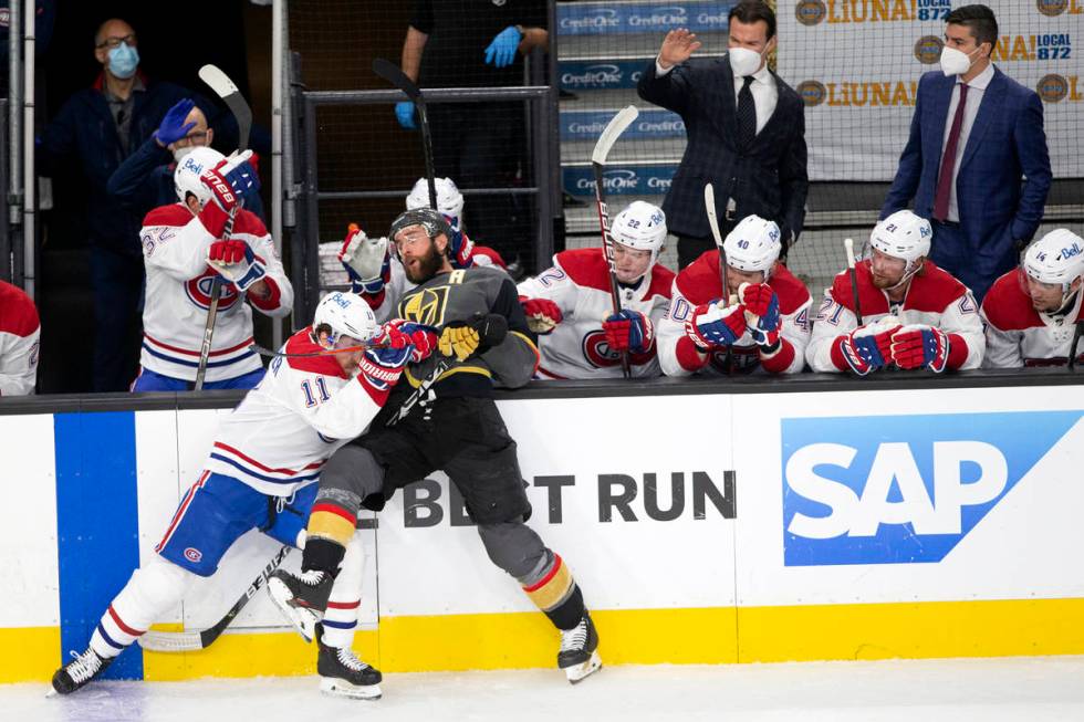 Golden Knights defenseman Alex Pietrangelo (7) is slammed against the boards by Canadiens right ...