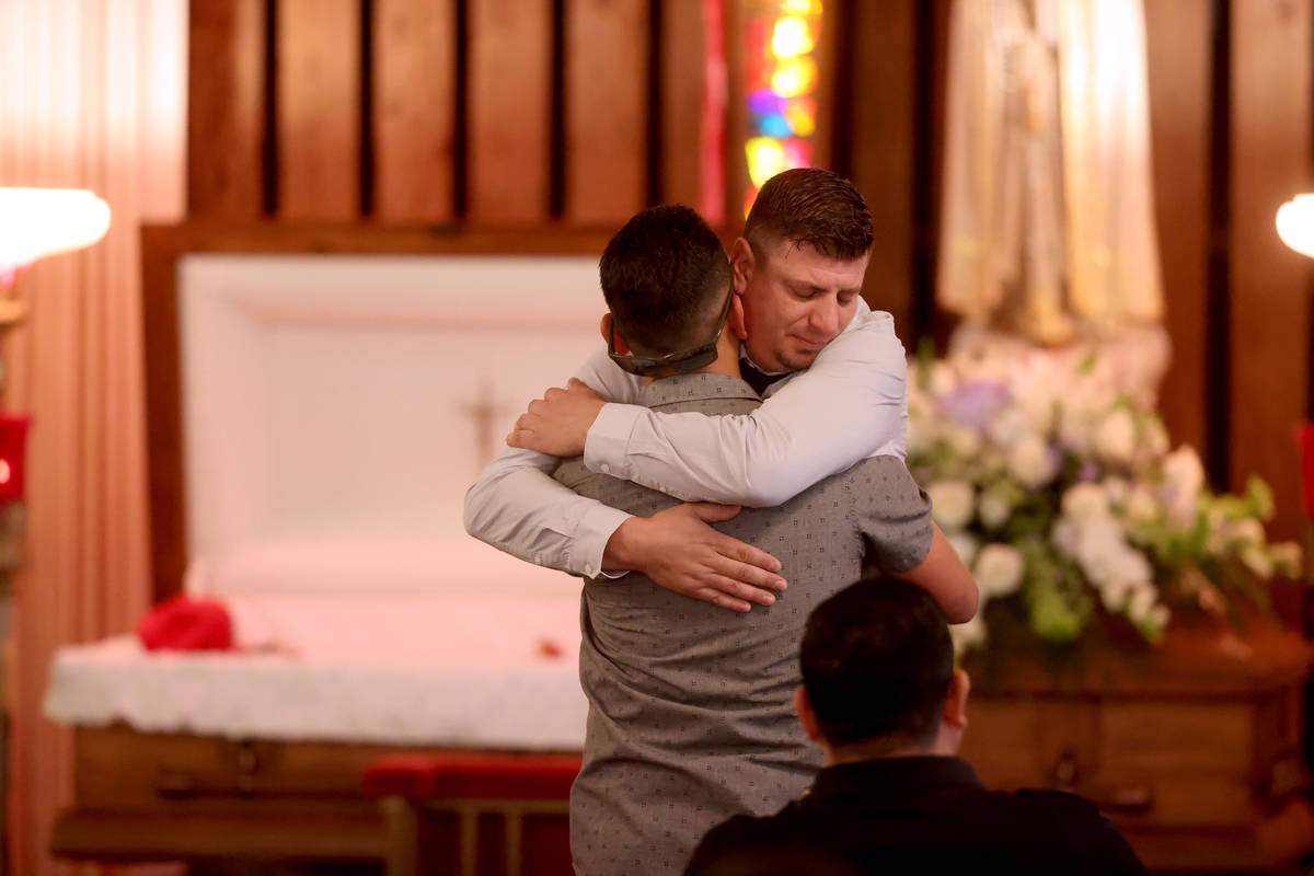 Nicholas Husted, facing, hugs friend Peter Prum of San Jose during a funeral service for his so ...
