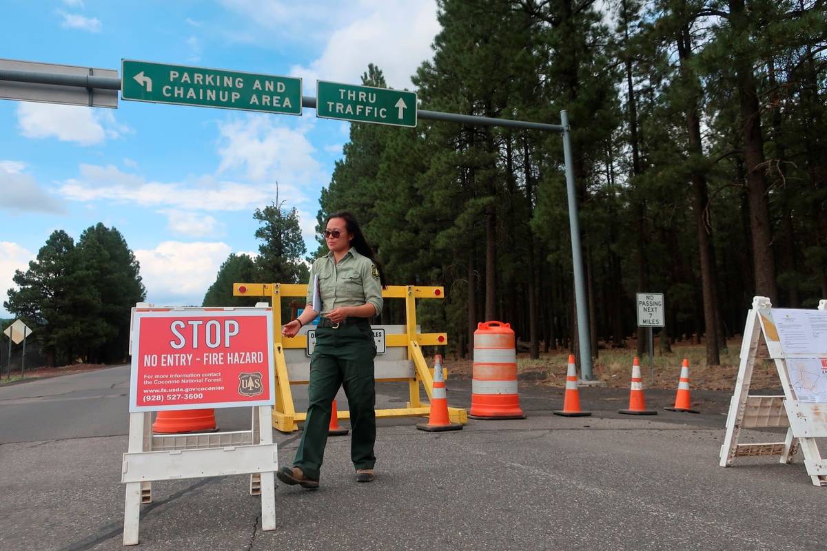 Coconino National Forest employee Amber Wong checks on the road signs outside Flagstaff, Ariz., ...