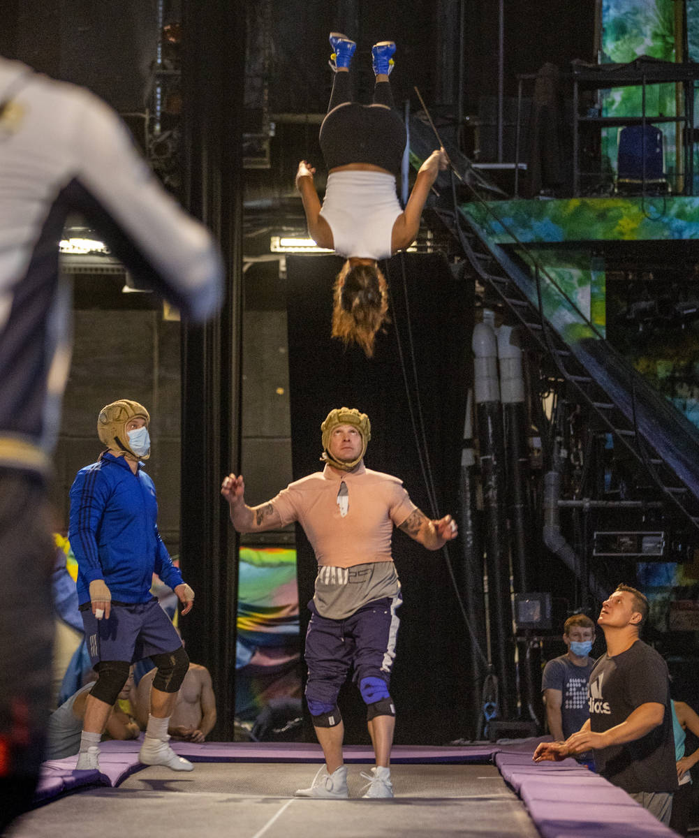 Acrobats practice flips and catches on a power track trampoline during rehearsals for "Mys ...
