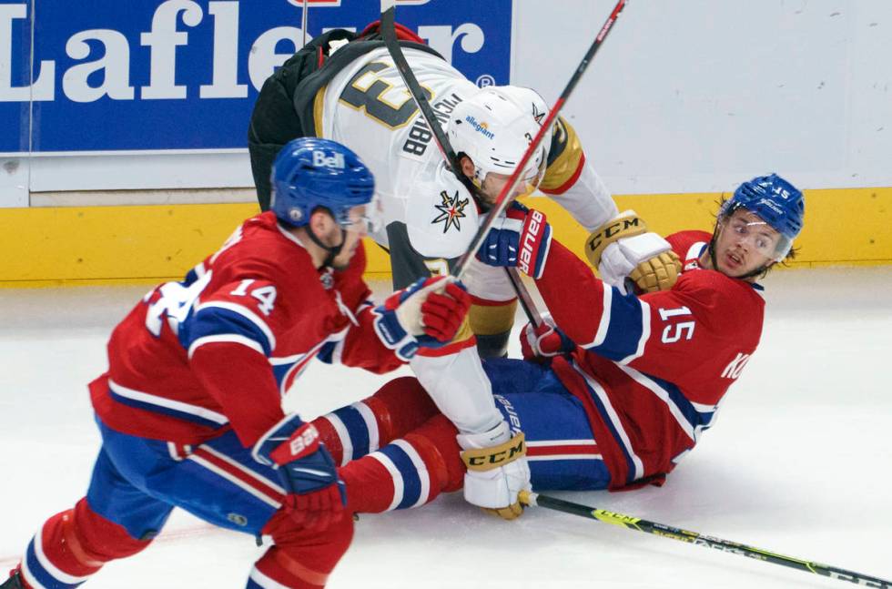 Montreal Canadiens' Jesperi Kotkaniemi (15) is dumped by Vegas Golden Knights' Peter DiLiberato ...