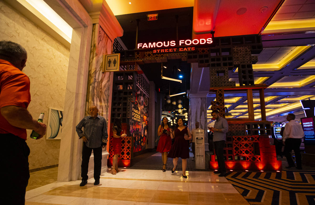 People walk by an entrance to the Famous Foods Street Eats area during the opening night of Res ...