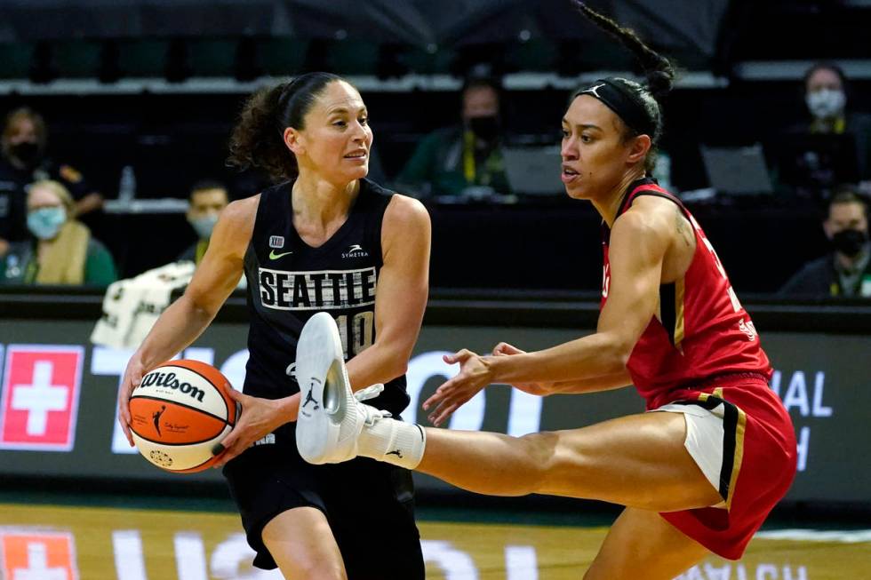 Seattle Storm's Sue Bird, left, looks for room to pass around Las Vegas Aces' Dearica Hamby in ...