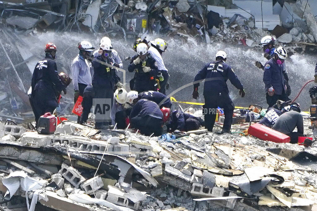 Rescue workers search the rubble of the Champlain Towers South condominium, Saturday, June 26, ...