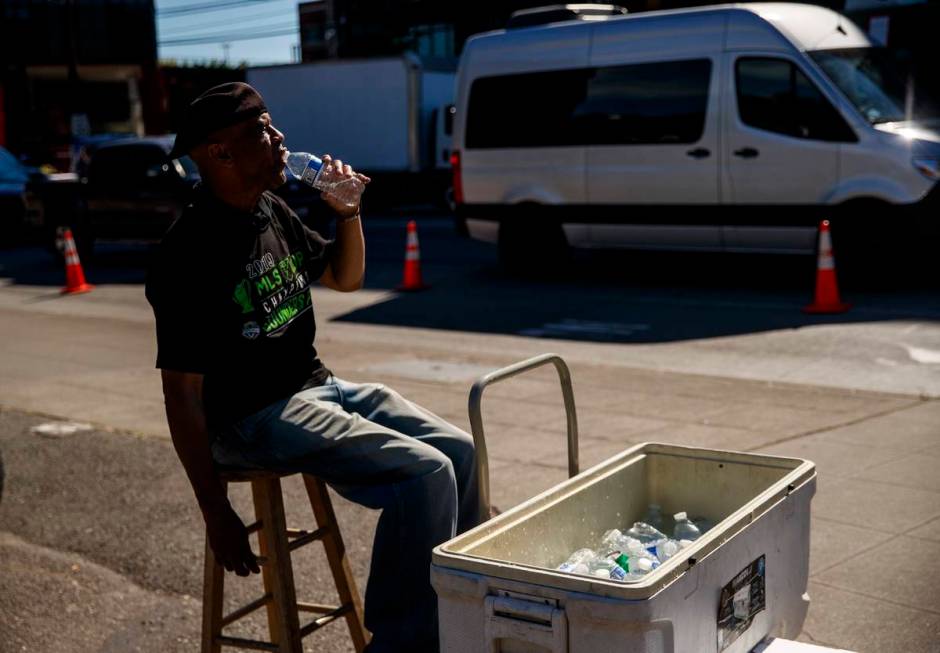 Carl Goodwin, manager of Seattle Sausage, takes a water break while selling bottles of water to ...