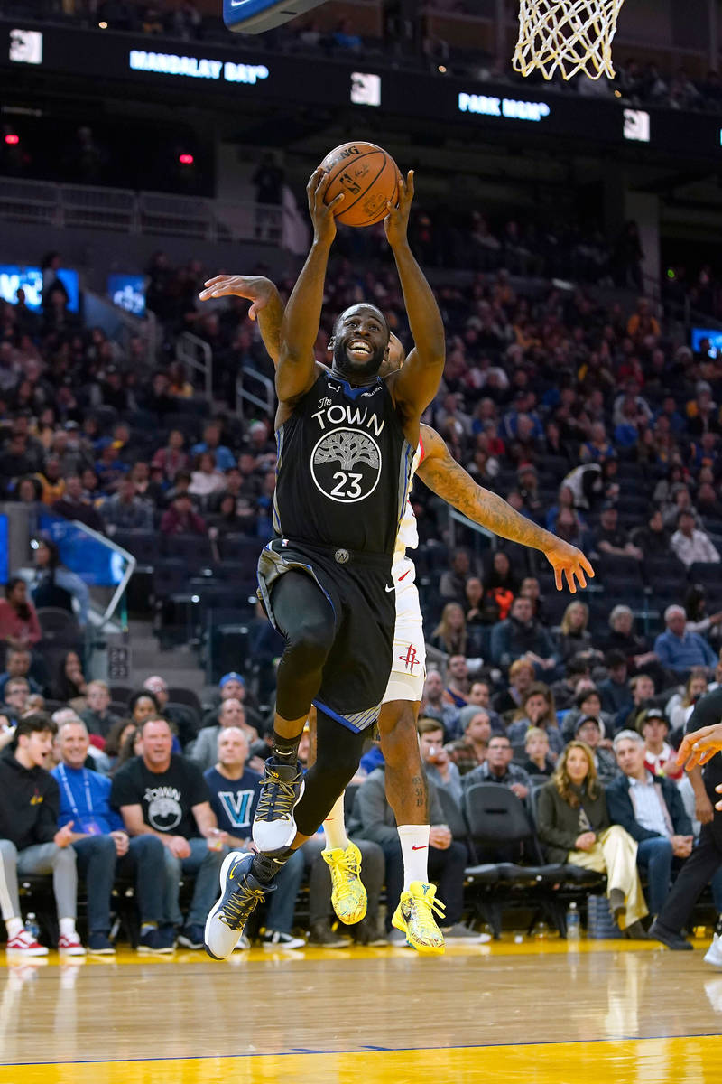 Golden State Warriors forward Draymond Green (23) drives to the basket in front of Houston Rock ...