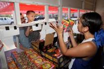Ayden Madrid, 8, gets a boost from his dad Joshua Madrid while checking out fireworks shown by ...