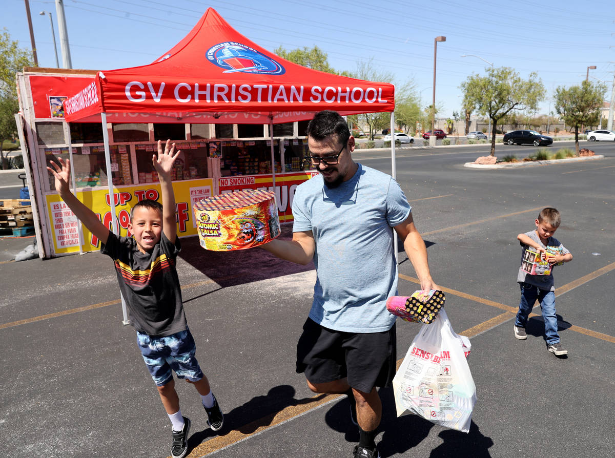 Ayden Madrid, 8, his dad Joshua Madrid and brother Lennox Madrid, 5, load fireworks bought at t ...