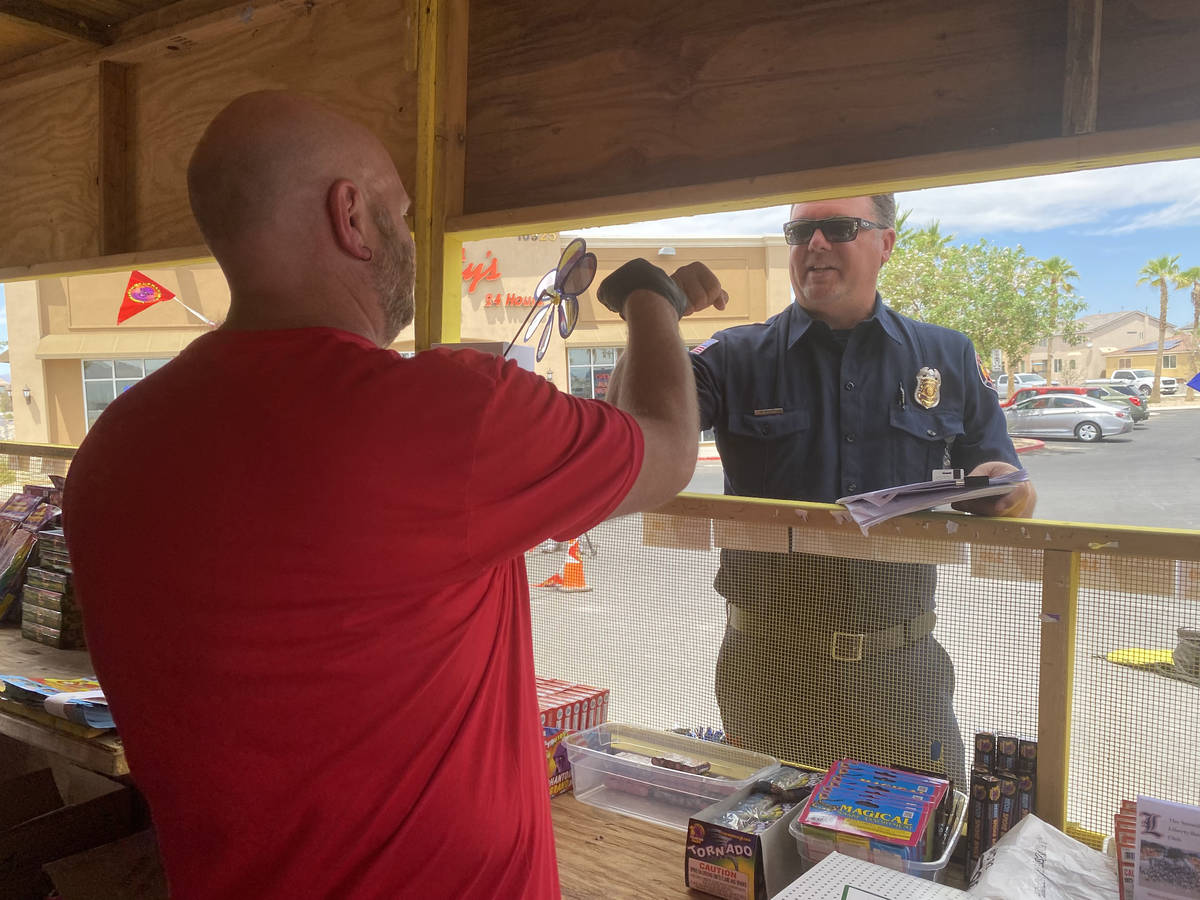 Clark County Fire Inspector Nick Giolito speaks with fireworks vendor Lane Barlow on Monday at ...