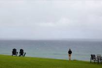 A person stands in front of the Pacific Ocean at The Cliffs at Princeville resort in Kauai in M ...