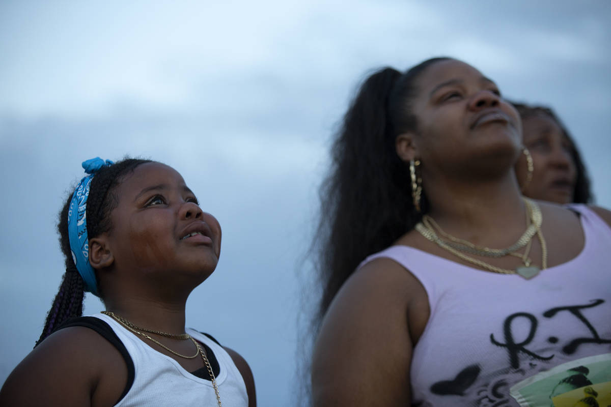 Anaeja Crew, 8, left, and Victoria Johnson, right, both relatives of Shania James, cry as they ...
